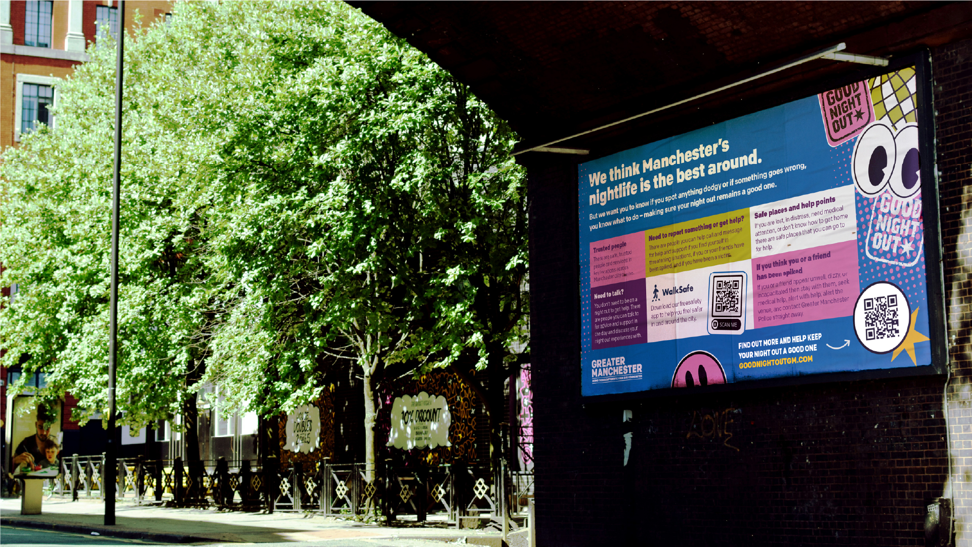 Image of a billboard ad for Good Night Out Guide under a bridge with trees in the background