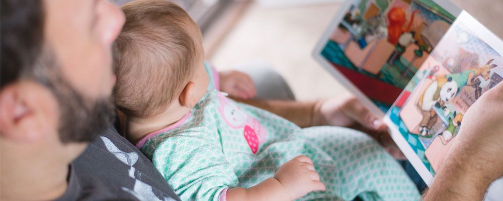 A father reading with his baby child.