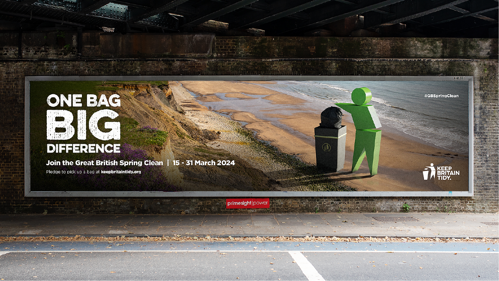 A billboard showing the Keep Britain Tidy icon man picking up litter in by the coast.